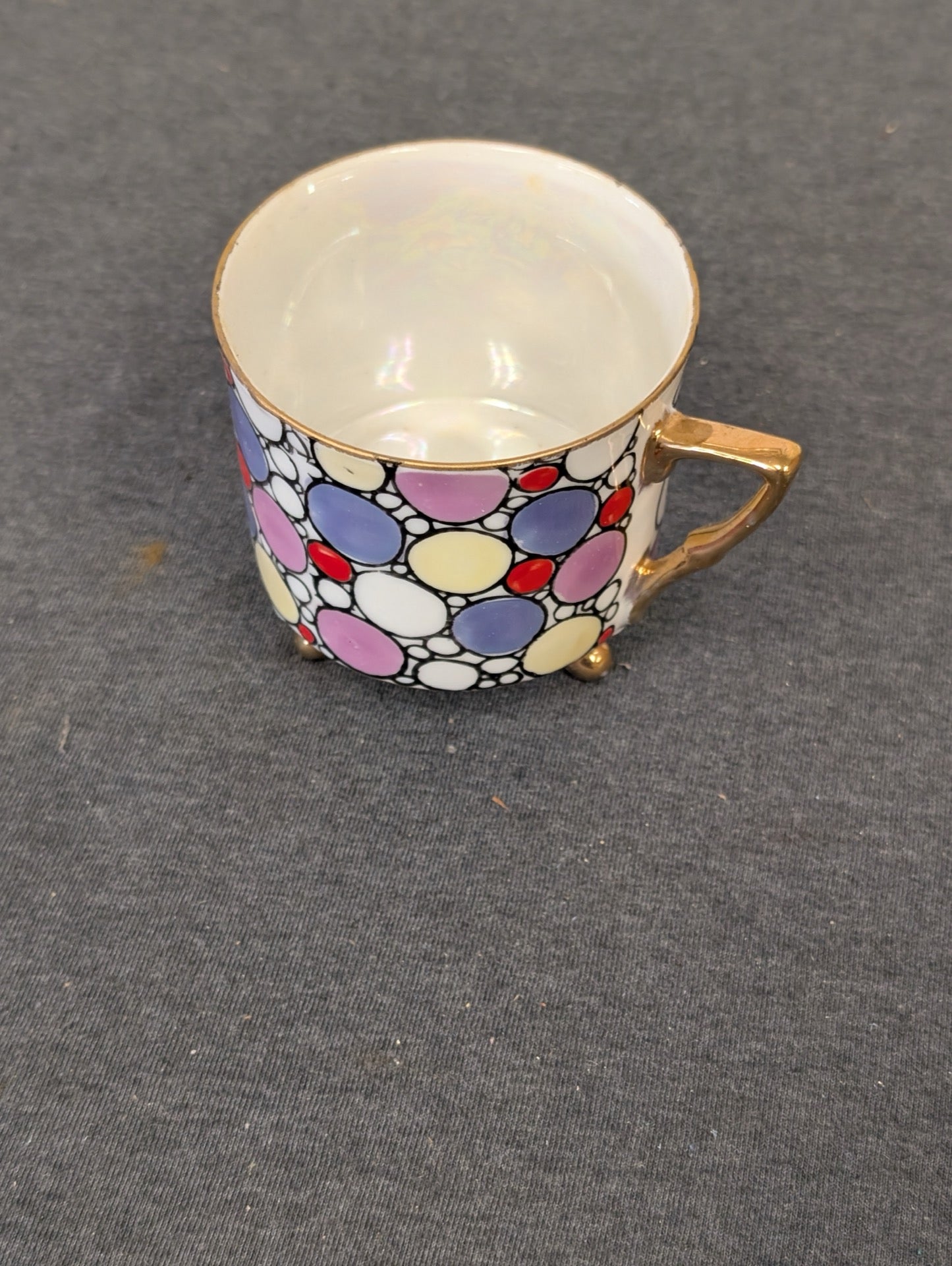 Vintage teacup with colorful polka dots, gold handle, and iridescent inner glaze