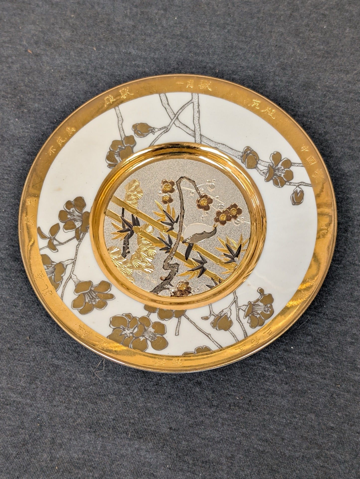 Front view of the Hamilton Collection Chokin Friendship plate with metallic bird design and gold rim.