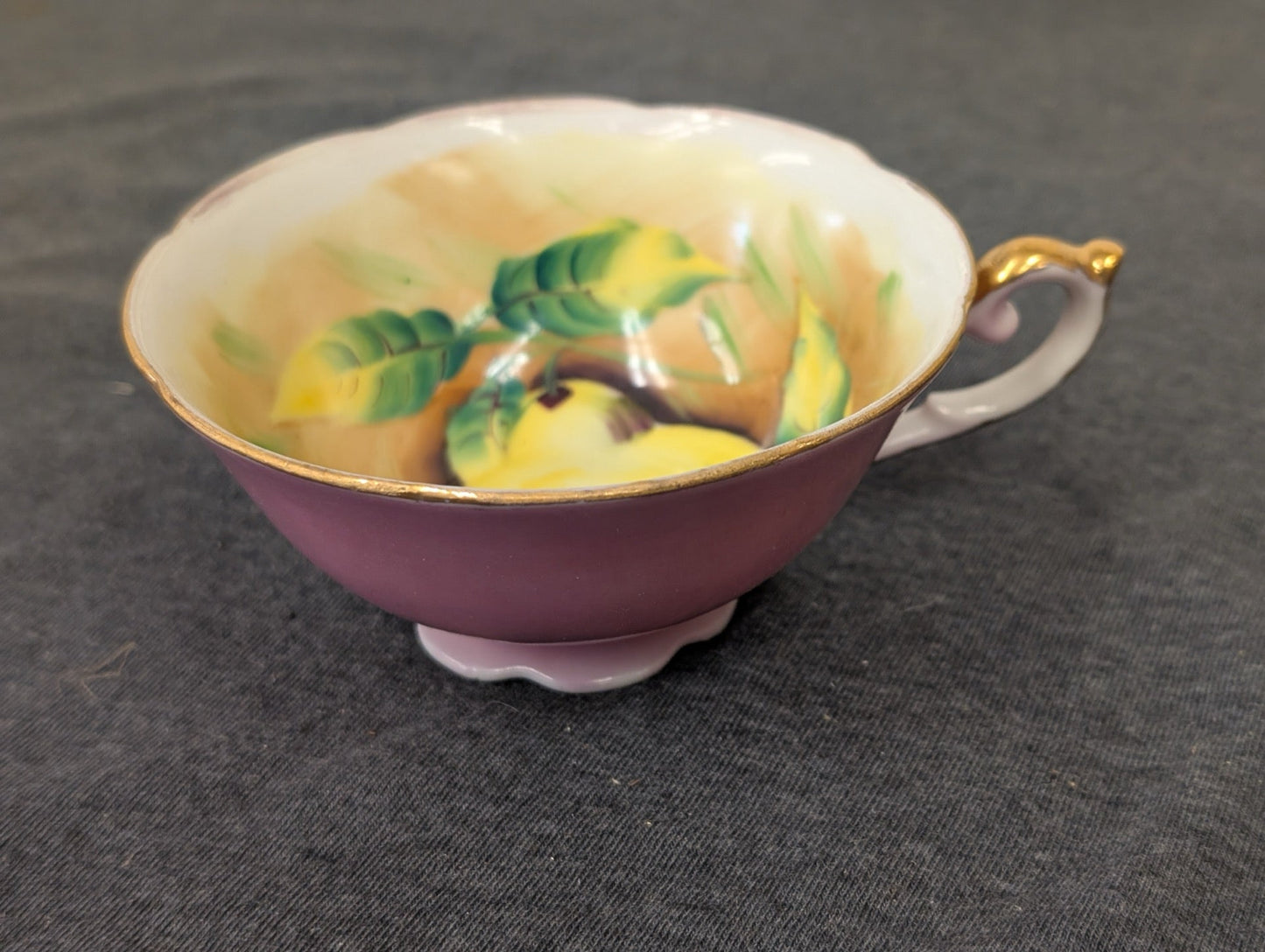 Vintage pink teacup made in Occupied Japan with hand-painted fruit interior, side angle.