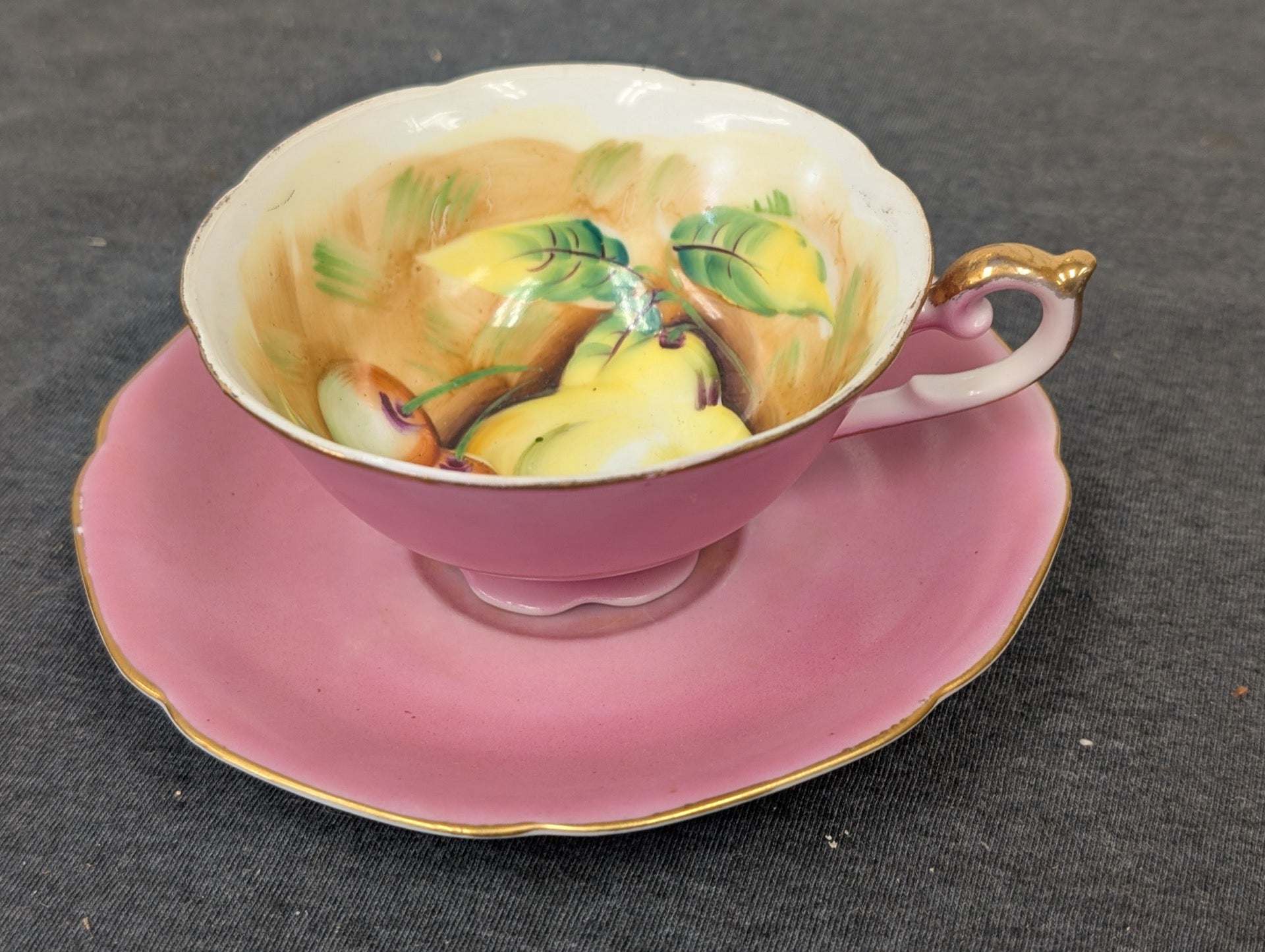 Vintage pink teacup and saucer made in Occupied Japan with hand-painted fruit interior.
