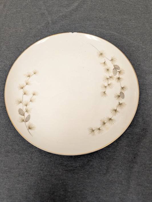 Front of Mikasa Sequoia 6141 plate with top edge chip and pinecone design