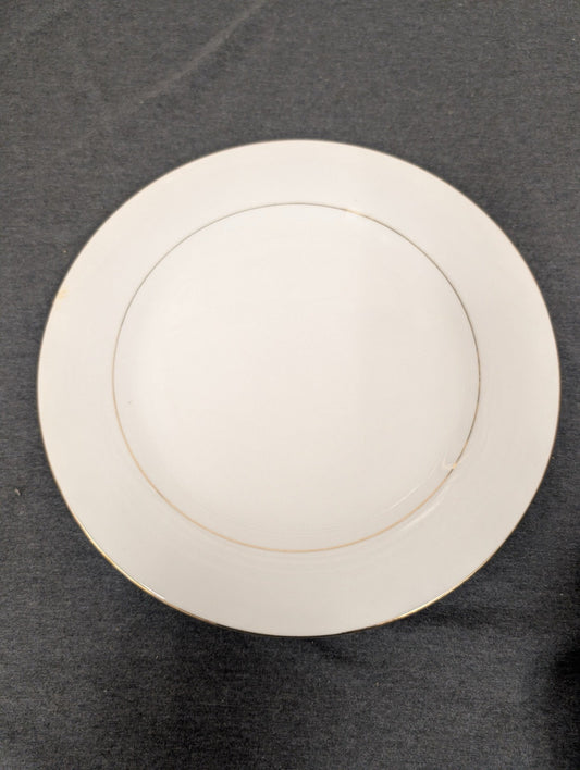 Front view of a white Sakura Classic Gold dinner plate with gold rim.