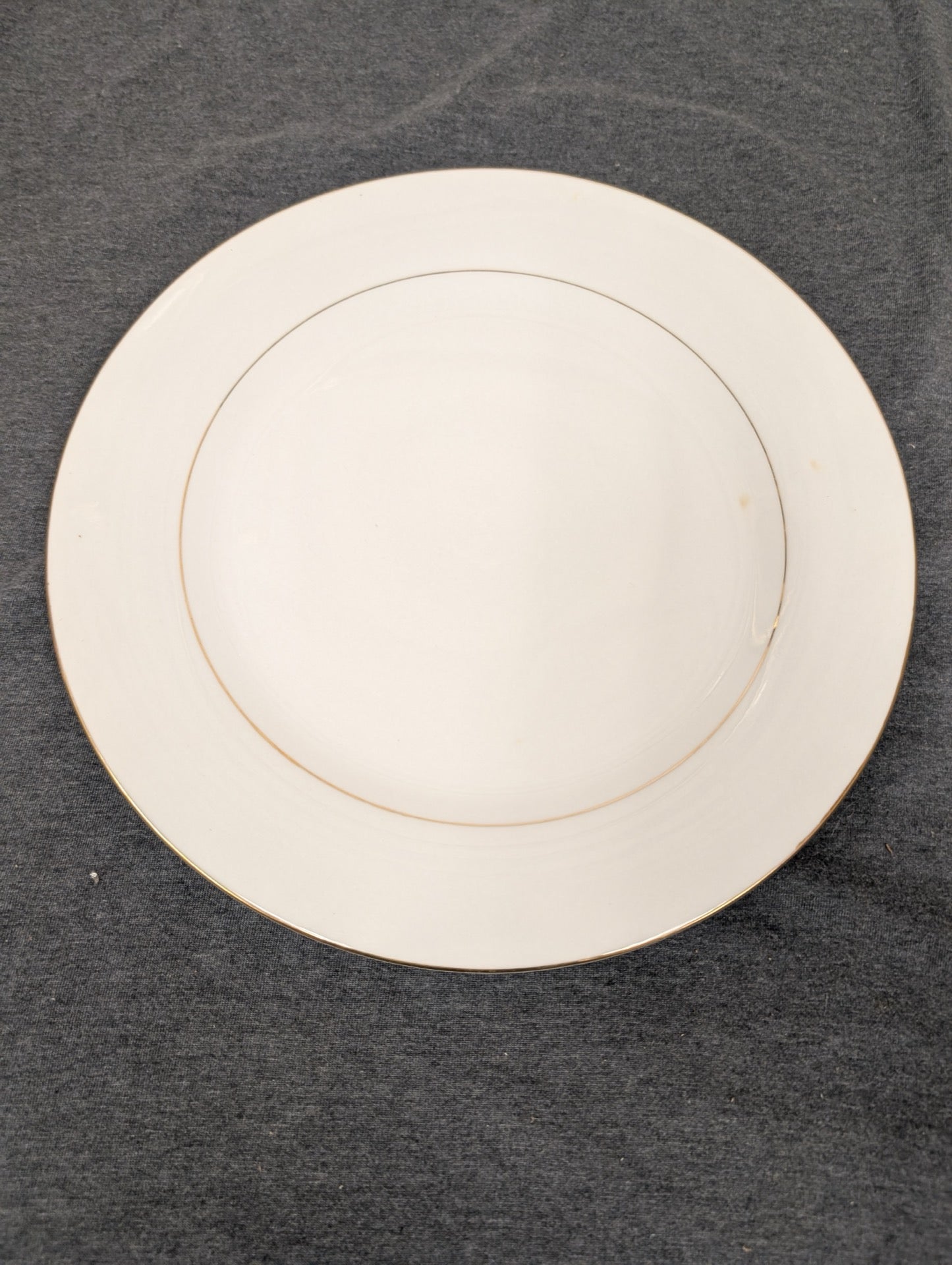Top-down view of Sakura white plate with thin gold rim.
