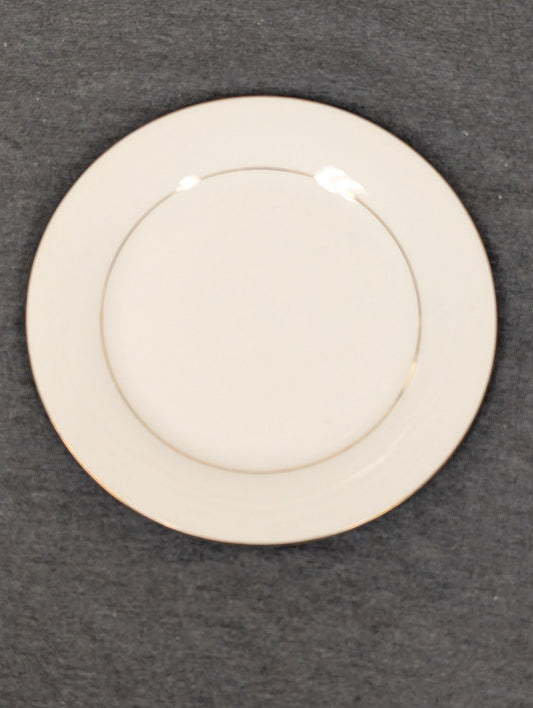 Front view of a white Sakura Classic Gold dinner plate with a gold band.