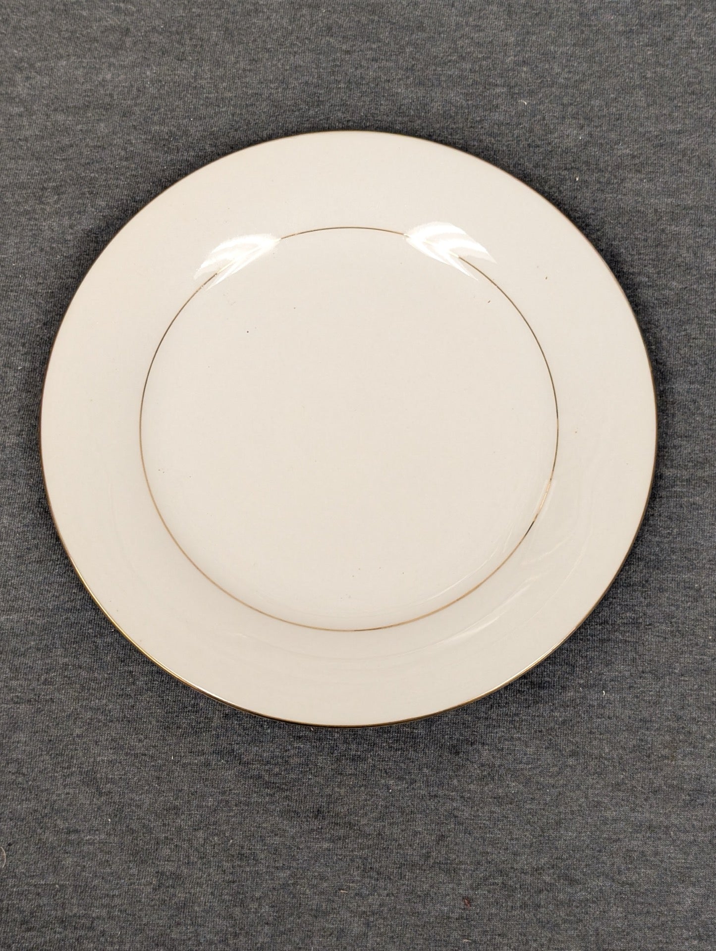 Front of a white Sakura Classic Gold plate with a gold band.