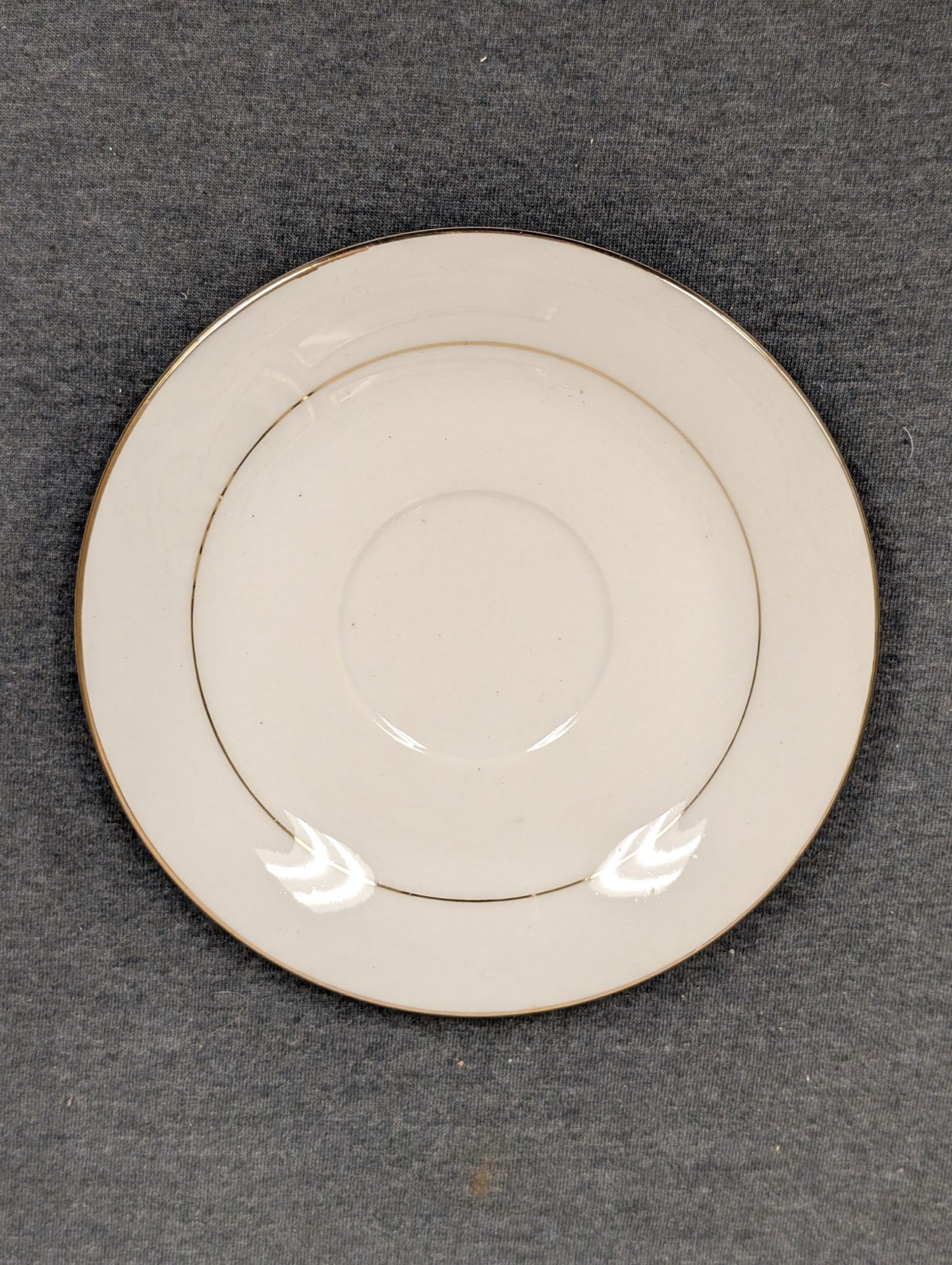Top view of white Sakura saucer with gold rim and inner ring