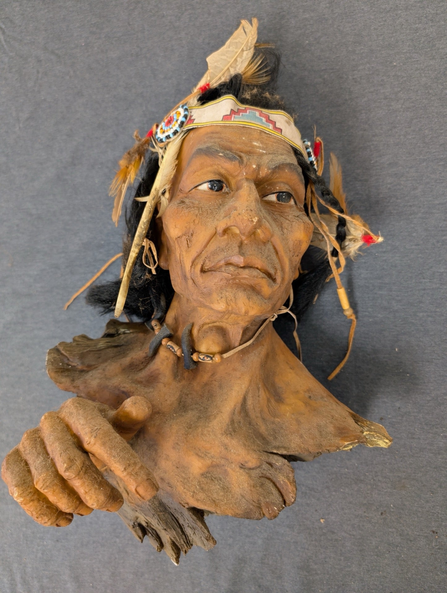 Detailed bust sculpture of a Native American chief with feathers and traditional garb