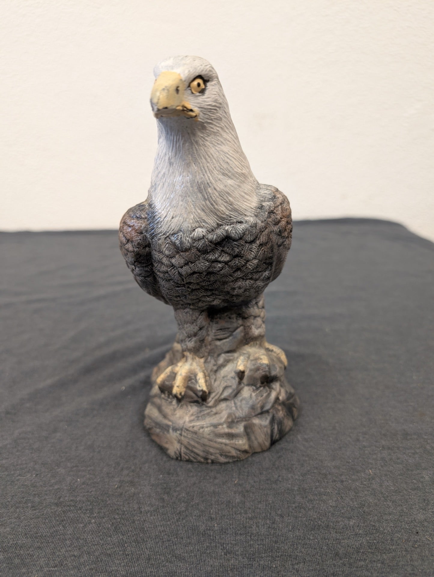 Small hand-painted resin figurine of a bald eagle standing on a rocky base