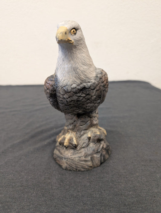 Small hand-painted resin figurine of a bald eagle standing on a rocky base