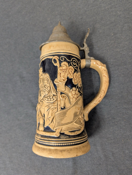 Vintage ceramic lidded beer stein featuring a relief of a man with grapes