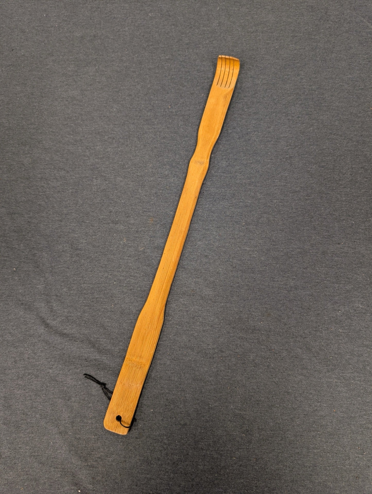 Long wooden bamboo backscratcher with curved fingers at the top