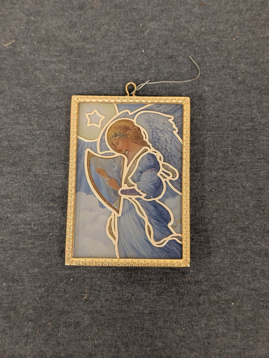 Rectangular glass suncatcher framed in gold metal showing an angel playing a harp