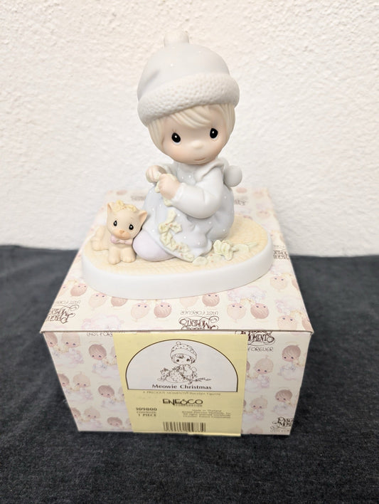 Precious Moments figurine of a girl and kitten sitting on its original box