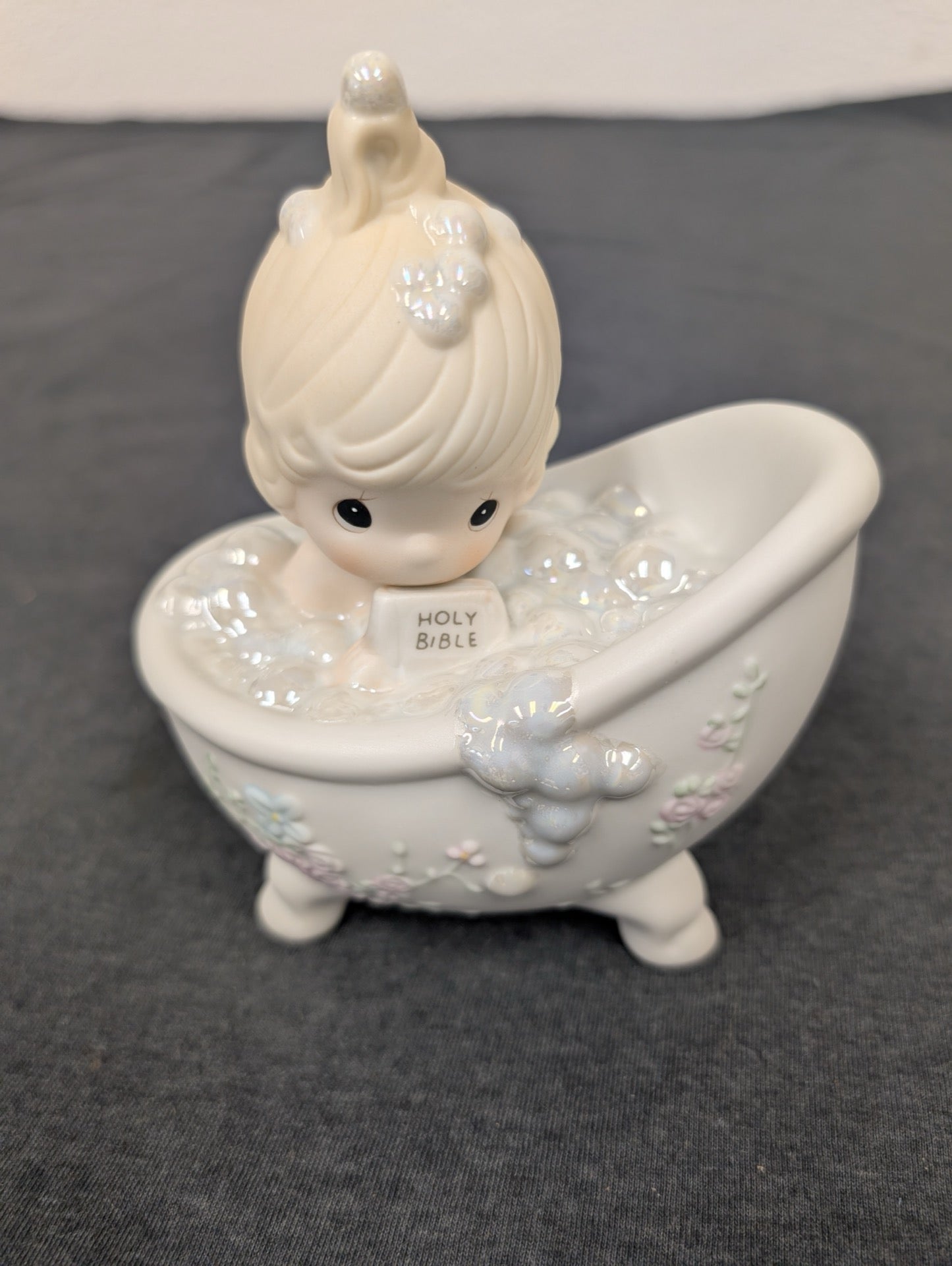 Precious Moments figurine of a child in a bubble-filled bathtub holding a Bible sponge