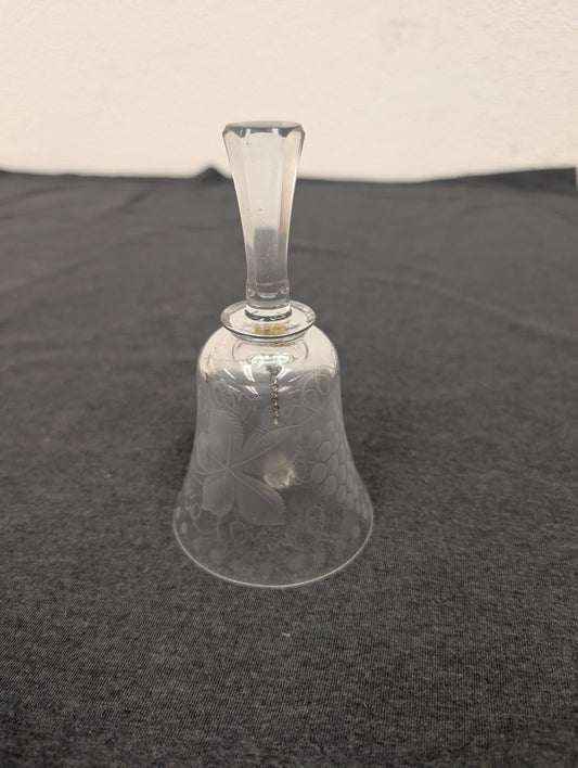 Clear glass bell with etched floral patterns and a long handle