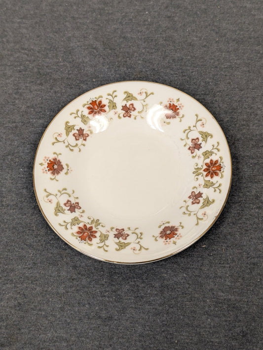 Small vintage fine porcelain saucer with a red and green floral border design.