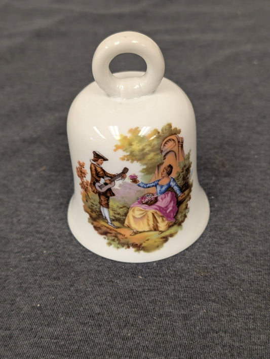 White vintage Limoges porcelain bell featuring a Fragonard courting couple painting.