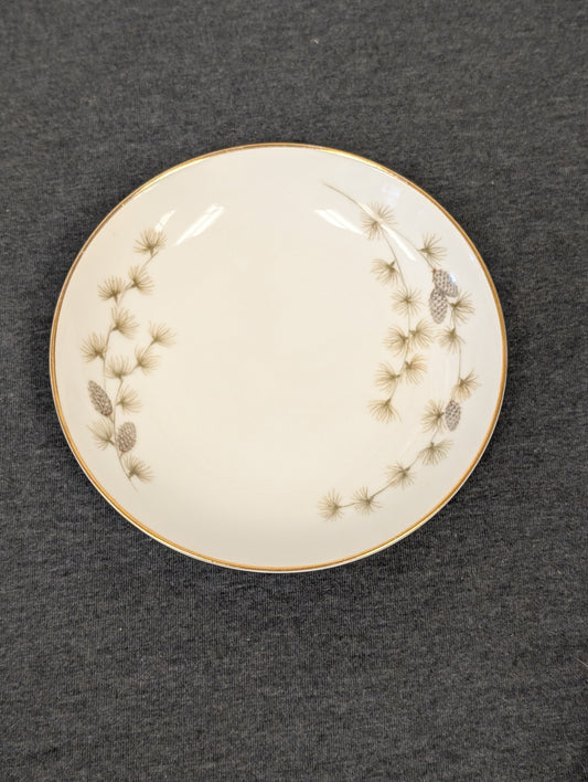 Front face showing the gold rim catching the light alongside the pine pattern.