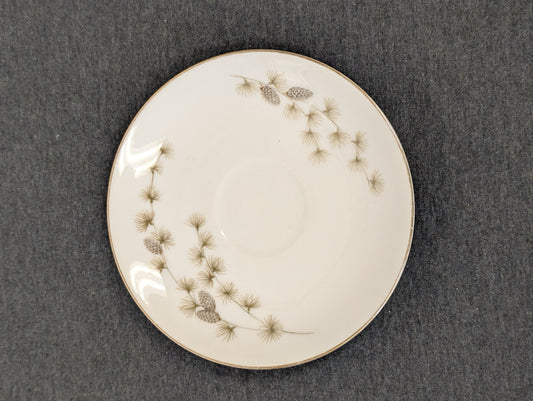 Top view of a vintage Mikasa Sequoia saucer with cup indentation and pinecone design