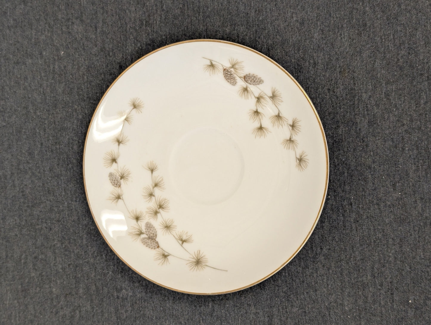 Elegant Mikasa Sequoia fine china saucer displaying a delicate pine pattern.