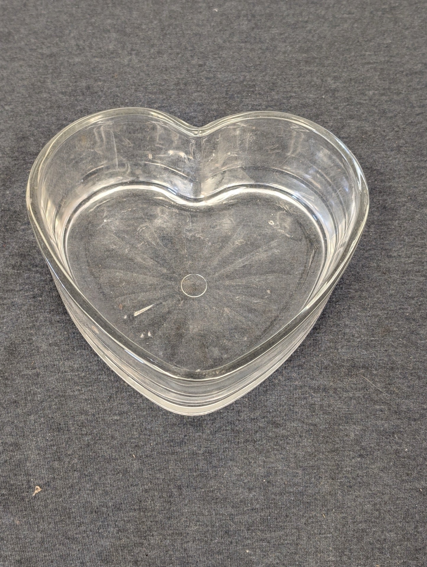 Clear glass heart shaped dish with starburst pattern inside