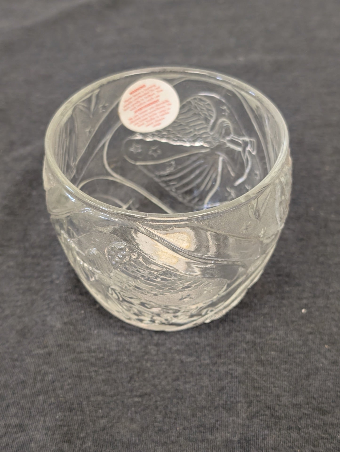 Clear glass bowl-shaped candle holder with etched angel and stars