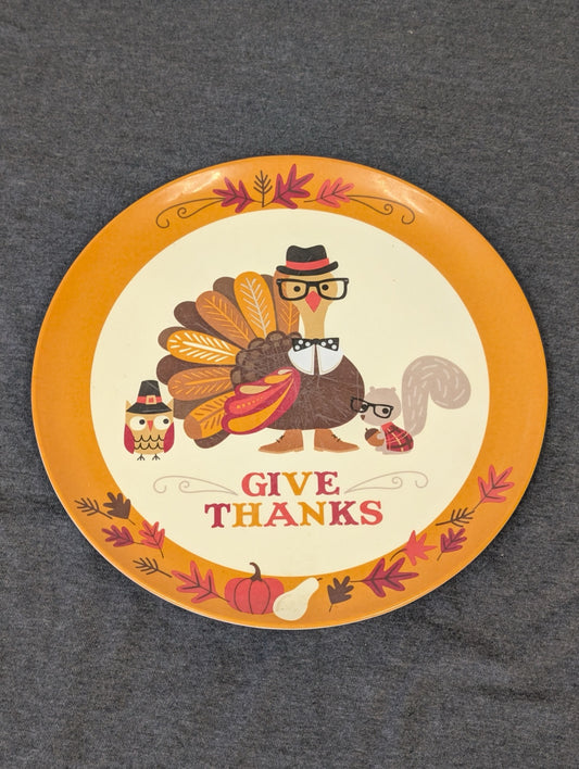Round orange and cream plate reading Give Thanks with a turkey, owl and squirrel wearing glasses and hats