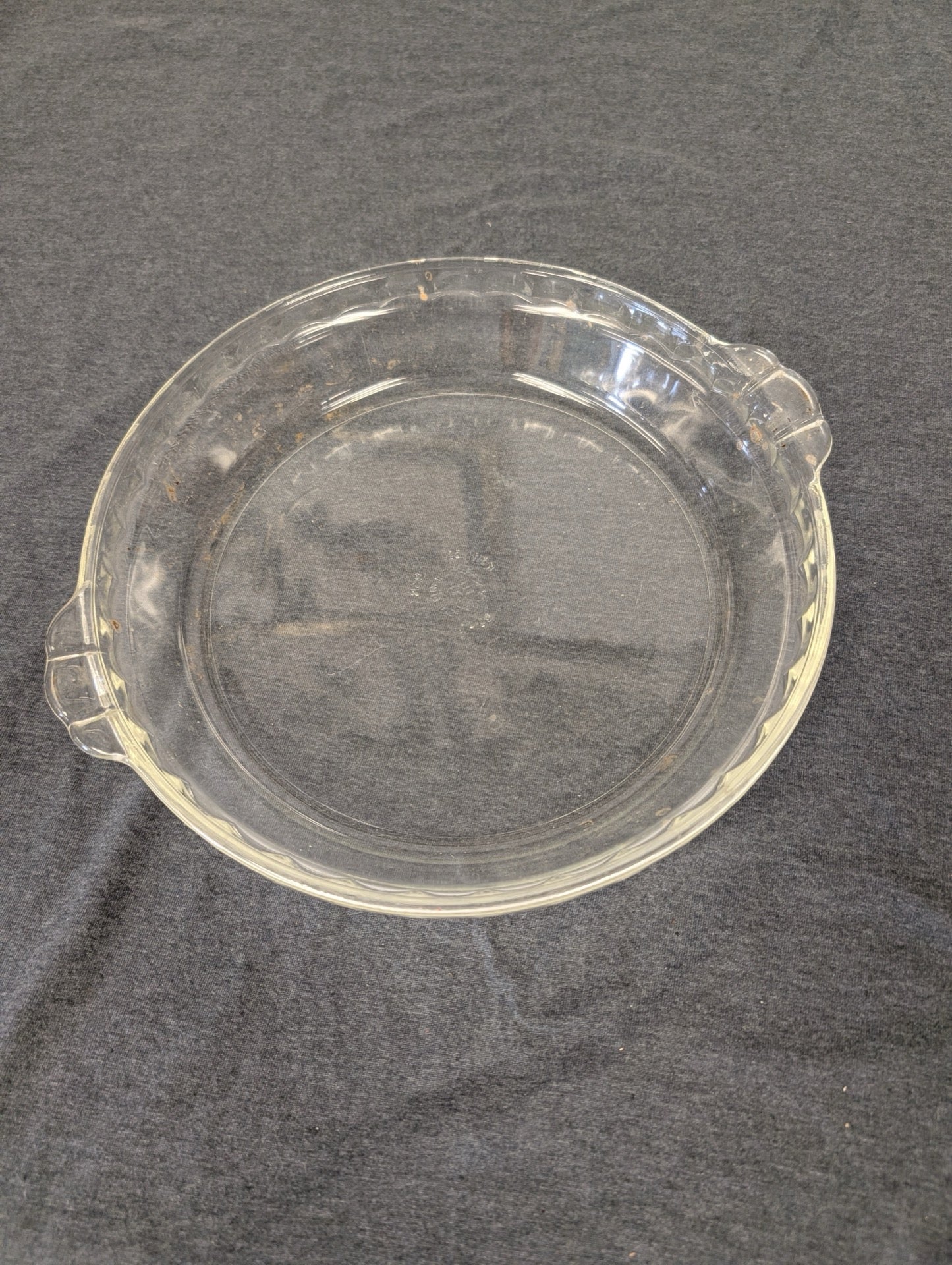 Clear glass pie plate with scalloped fluted edge and two small handles