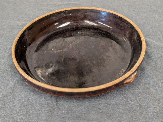 Dark brown glazed round pottery baking dish.