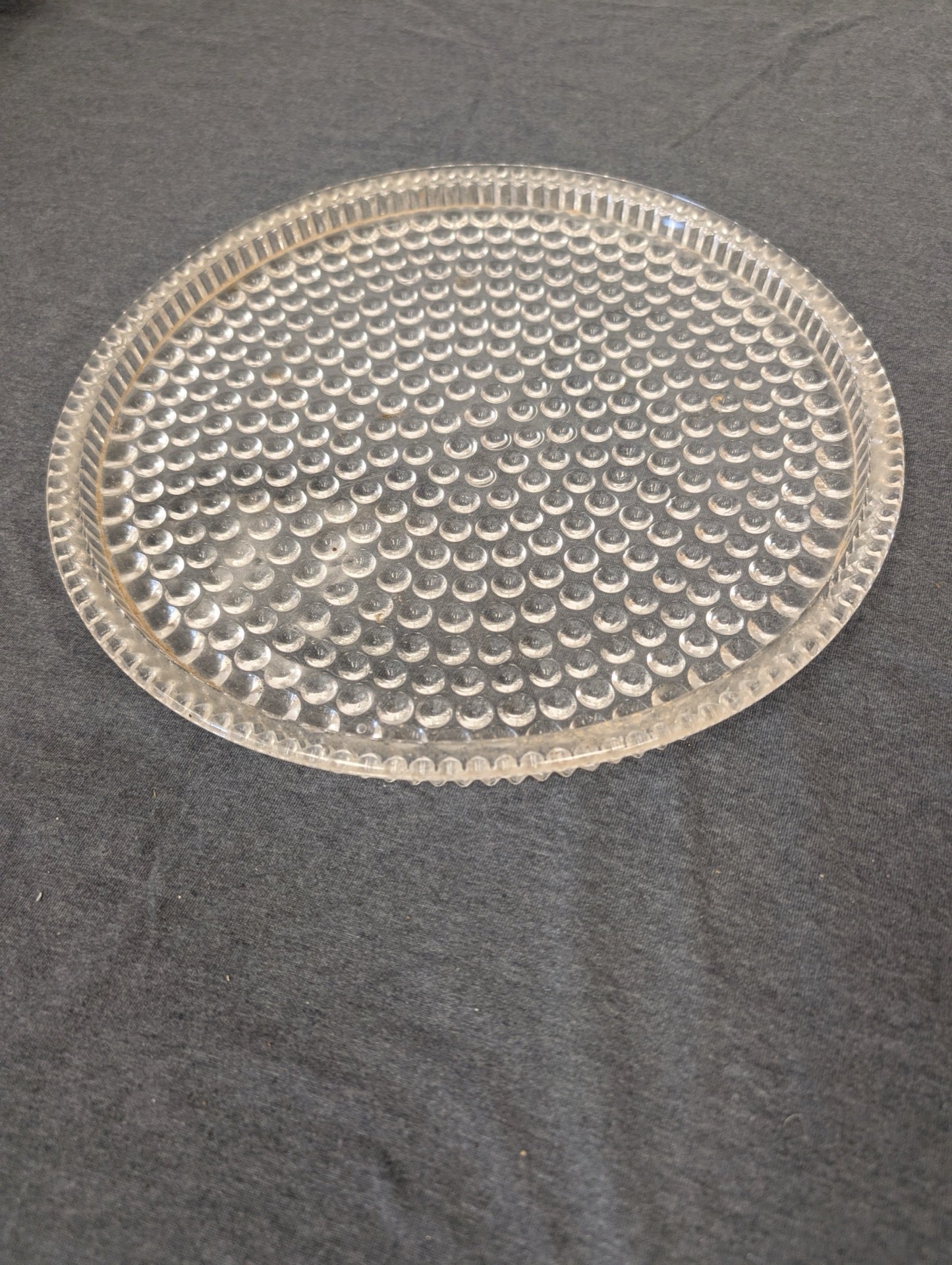 Clear glass shallow plate with a textured bubble pattern.