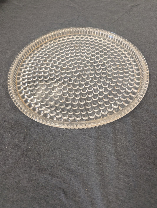 Clear glass shallow plate with a textured bubble pattern.