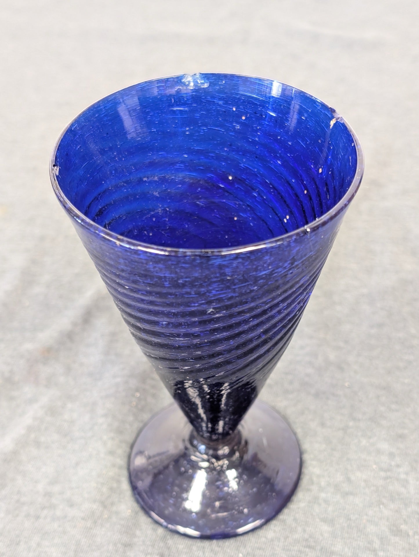 Cobalt blue glass stemmed water goblet with a spiral ribbed pattern.