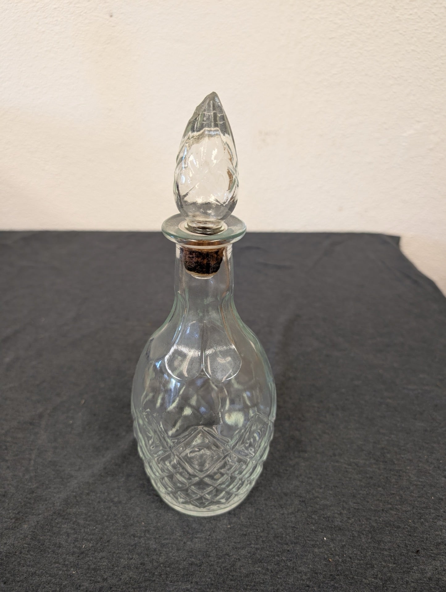Small clear pressed glass decanter with a diamond pattern and pointed stopper.