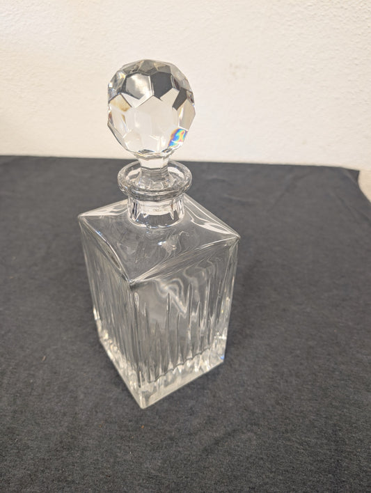 Fully assembled ribbed clear glass liquor decanter with faceted stopper.