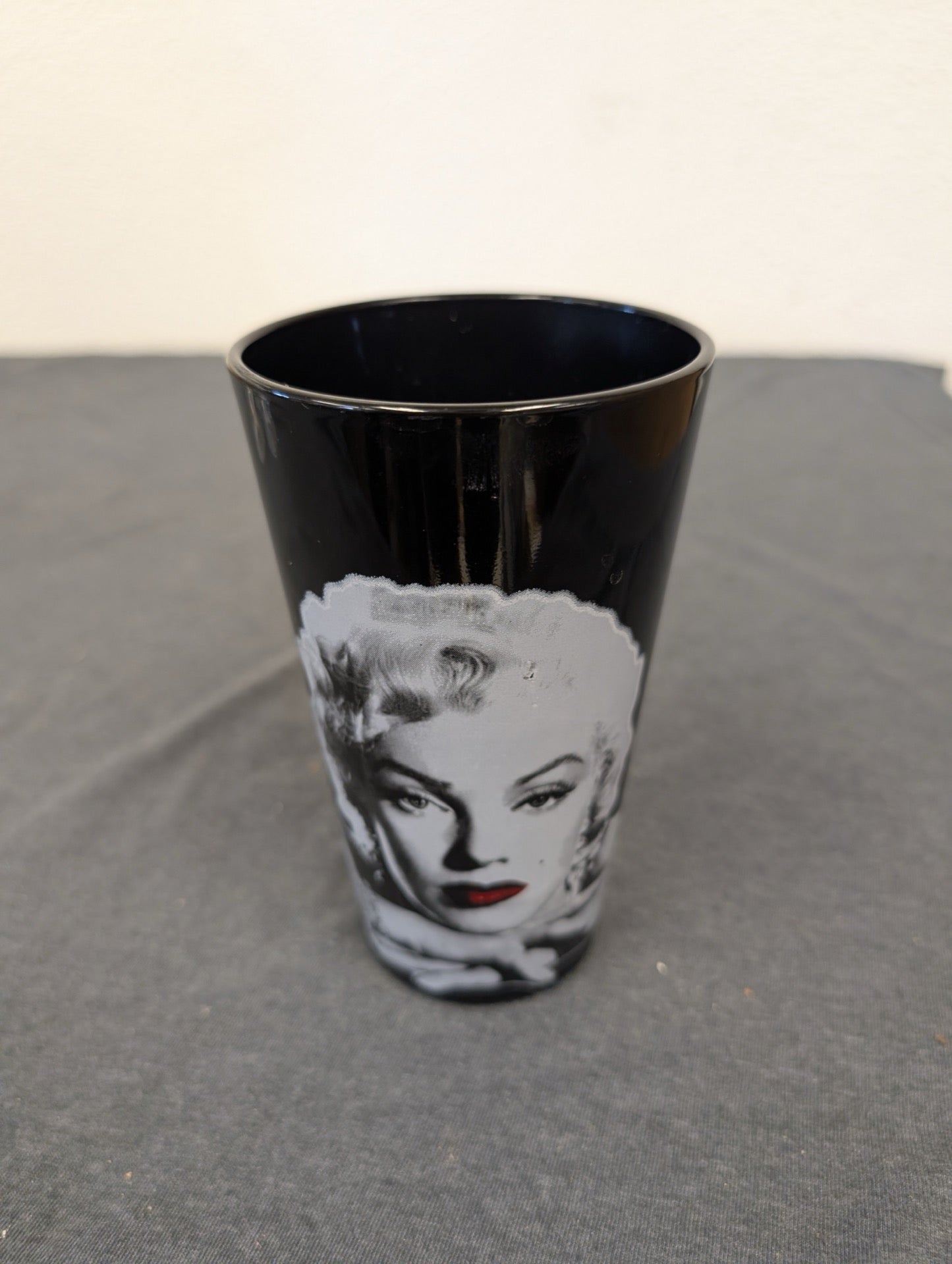 Black pint glass tumbler featuring Marilyn Monroe with bright red lips.