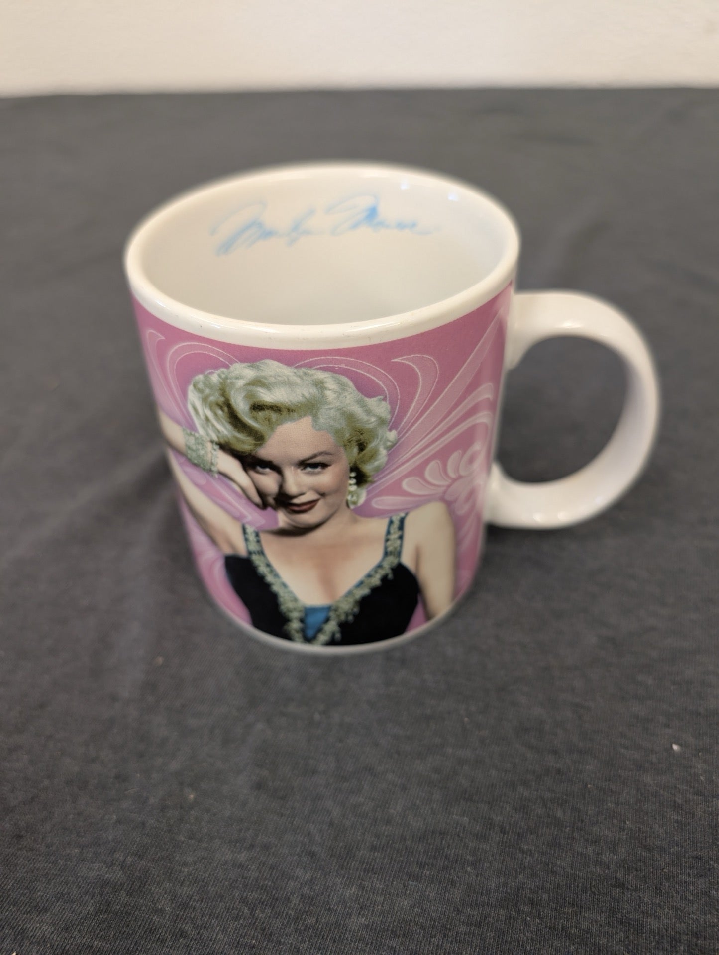 Pink ceramic coffee mug featuring a colorful portrait of Marilyn Monroe.