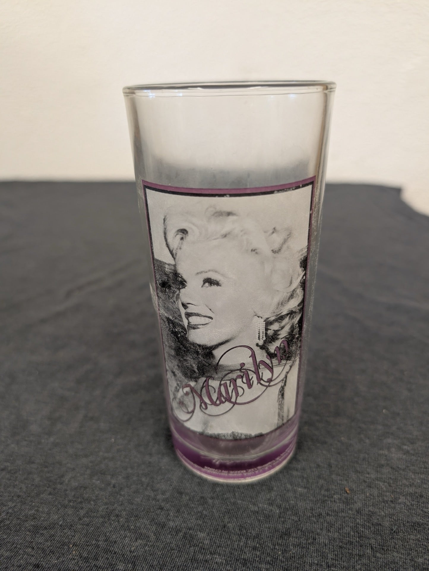 Glass tumbler showing a close-up black and white smiling portrait of Marilyn Monroe