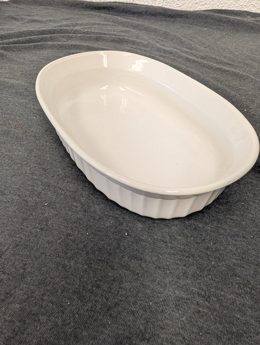 Top view of a clean, white, ribbed oval Corning baking dish