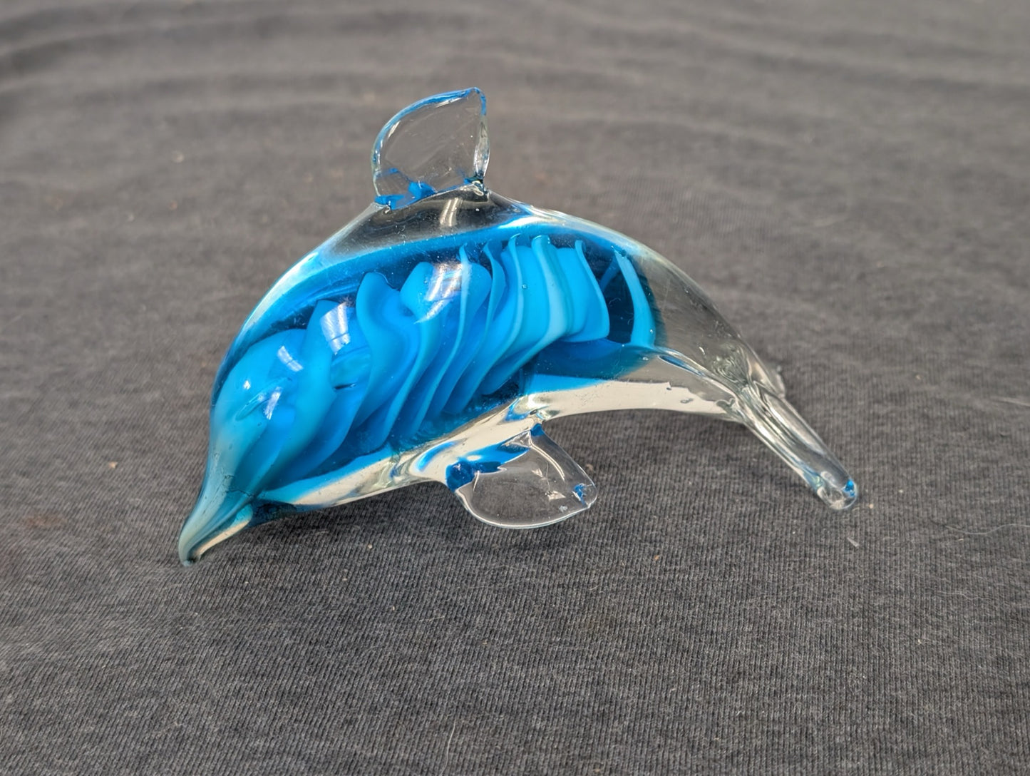 Clear glass dolphin figurine with a swirling blue interior