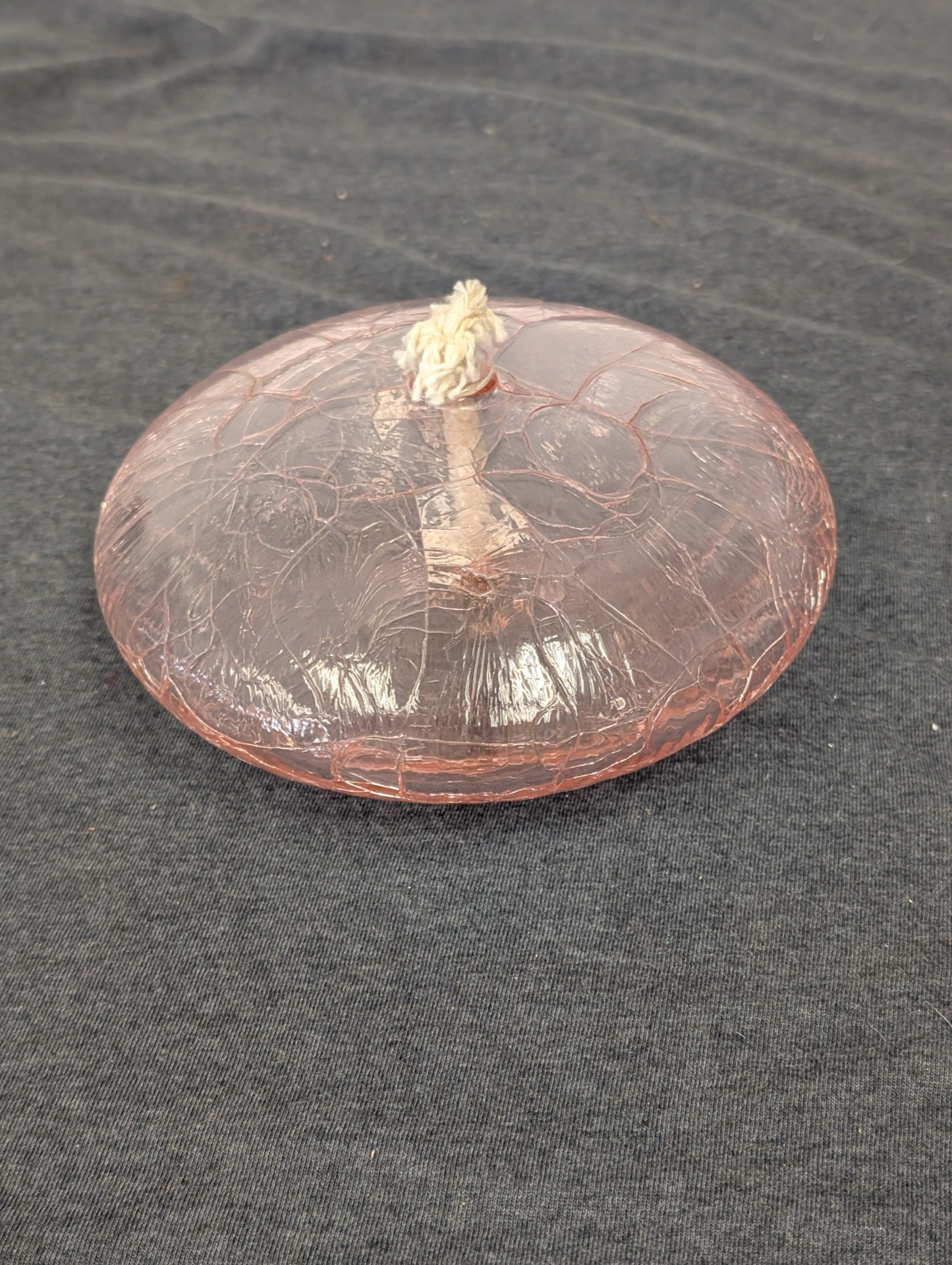 Flat round pink crackle glass oil lamp with a white wick