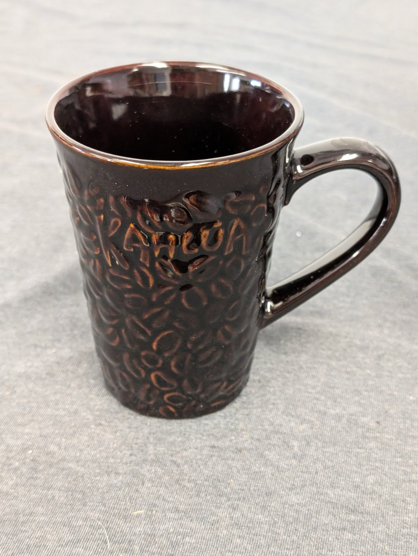 Dark brown ceramic mug featuring a textured coffee bean design and the word KAHLUA.