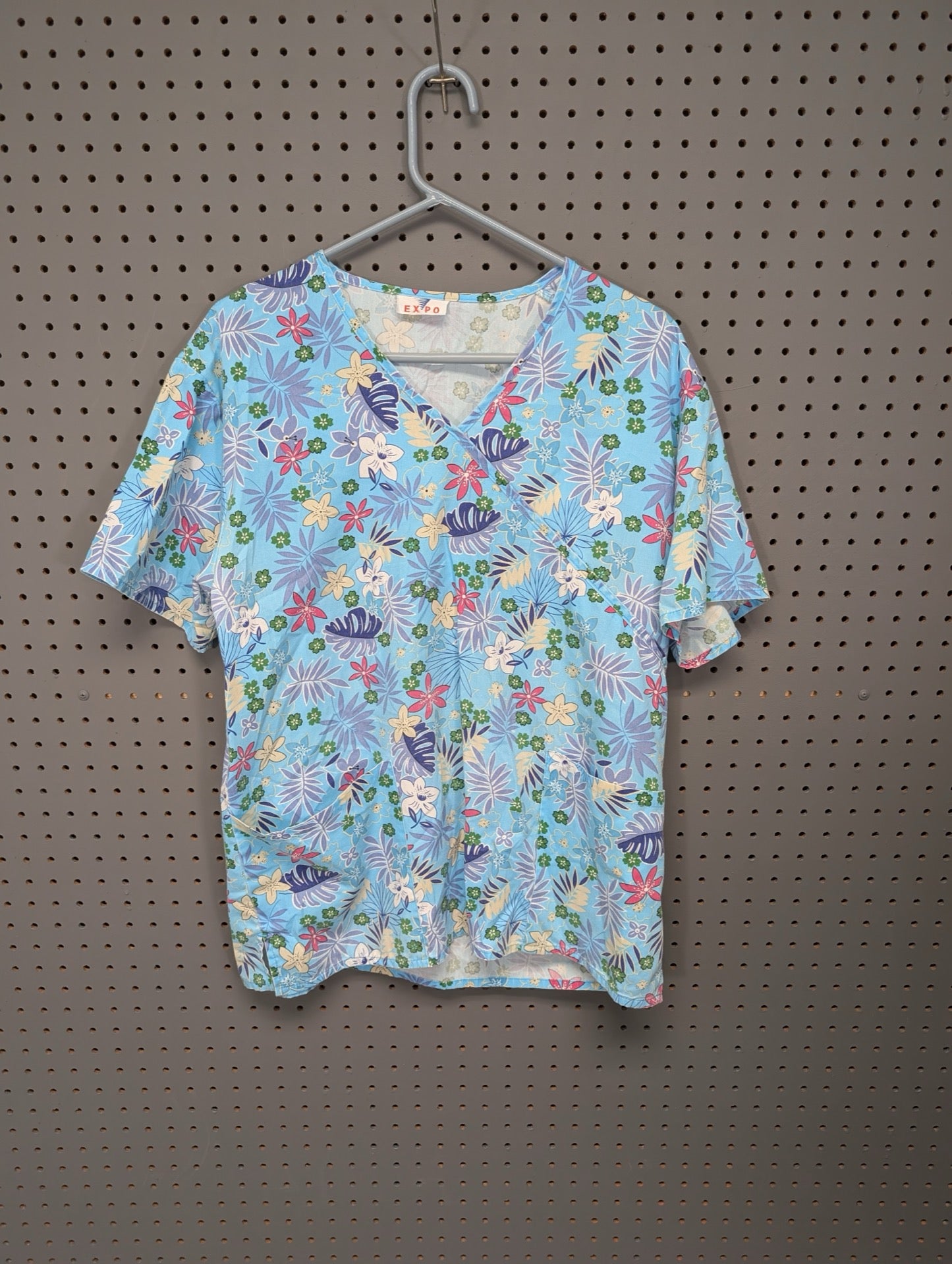 Front view of EXPO tropical floral scrub top