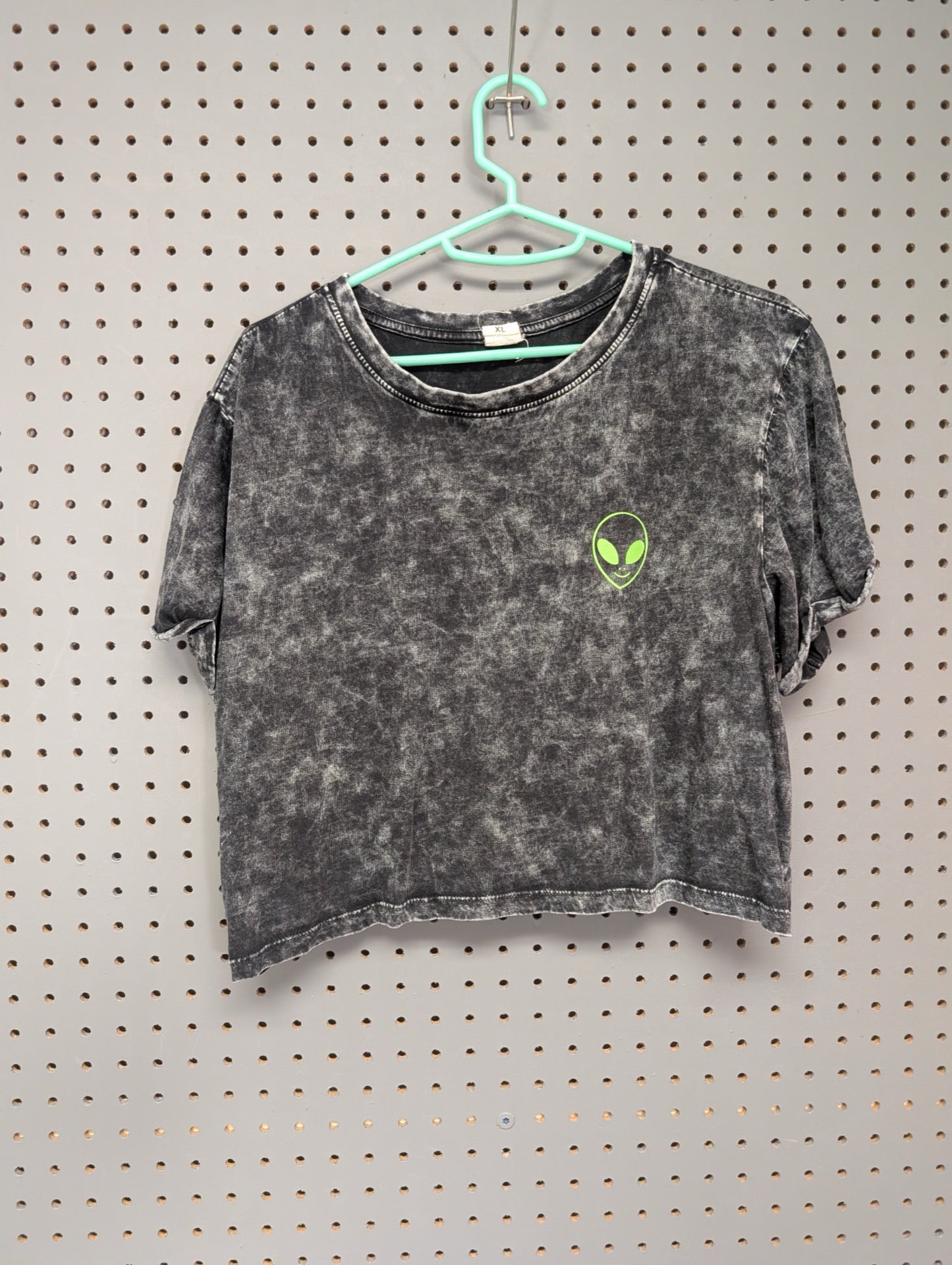 Front of acid wash crop top with small alien graphic