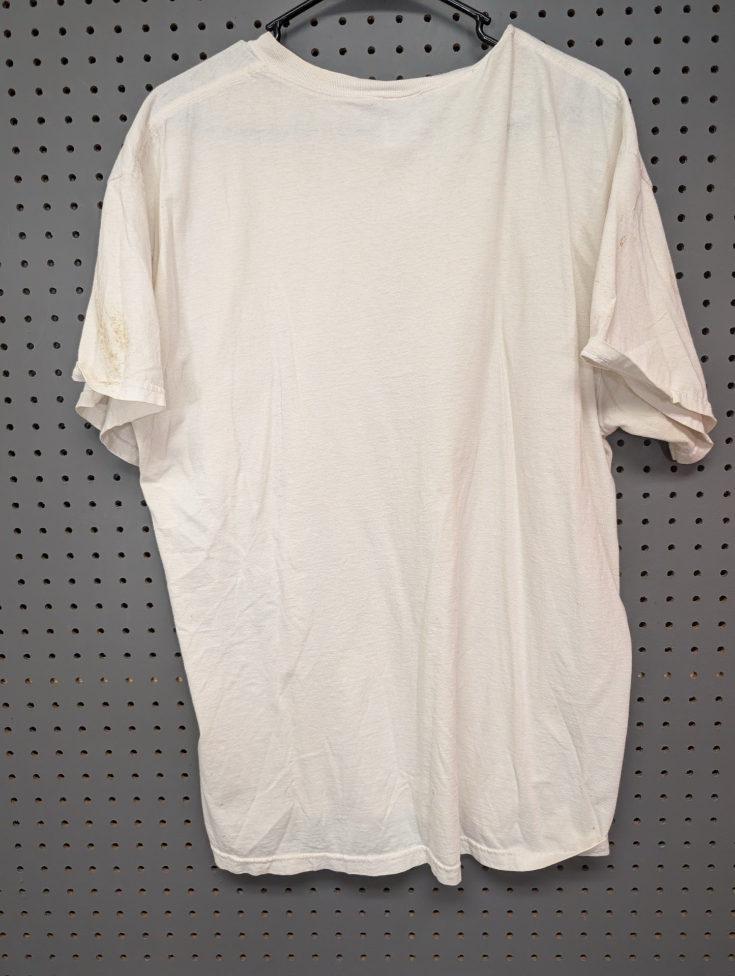 Back view of plain white t-shirt showing sleeve stains