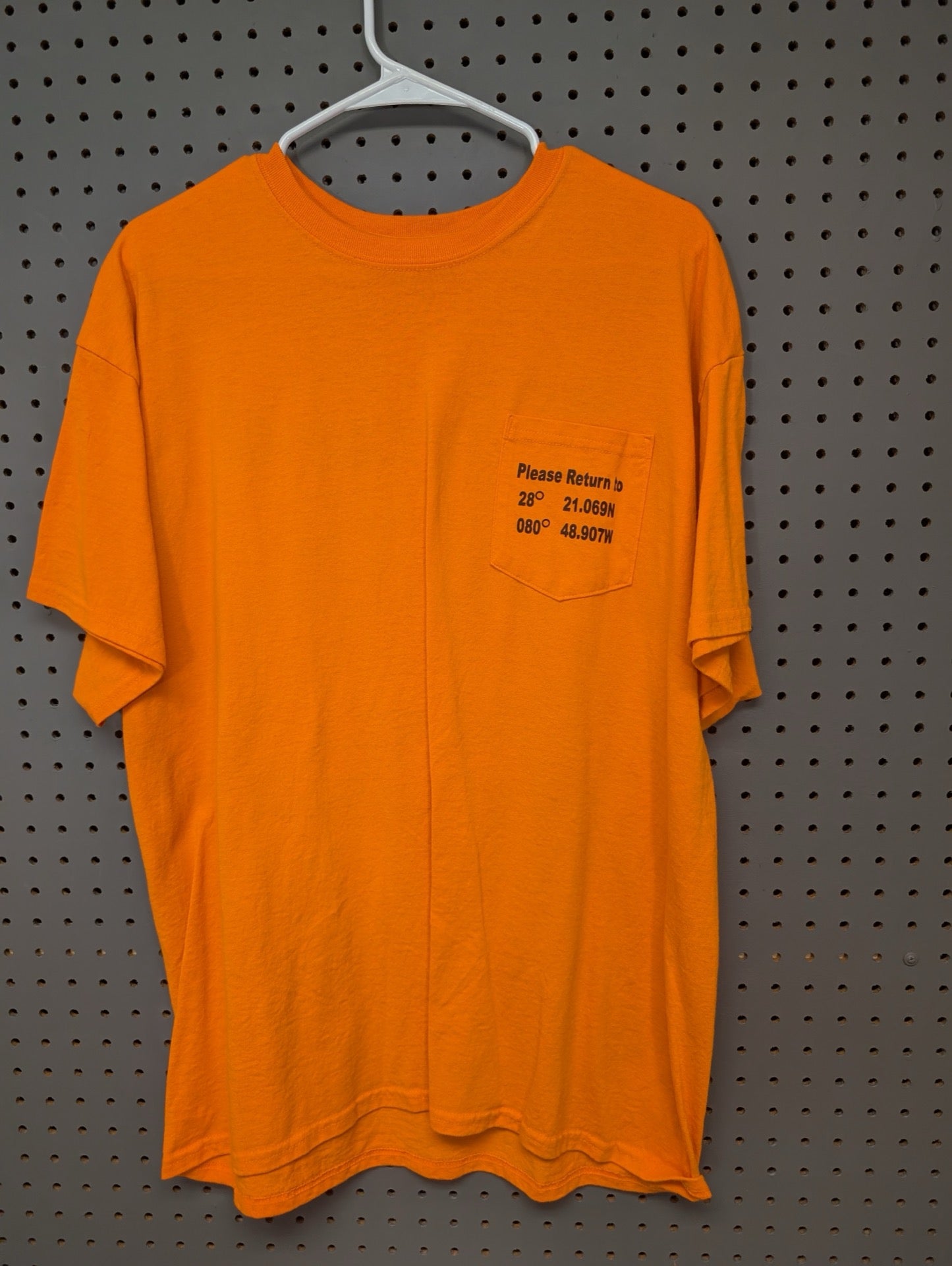 Front view of orange pocket t-shirt with GPS coordinates