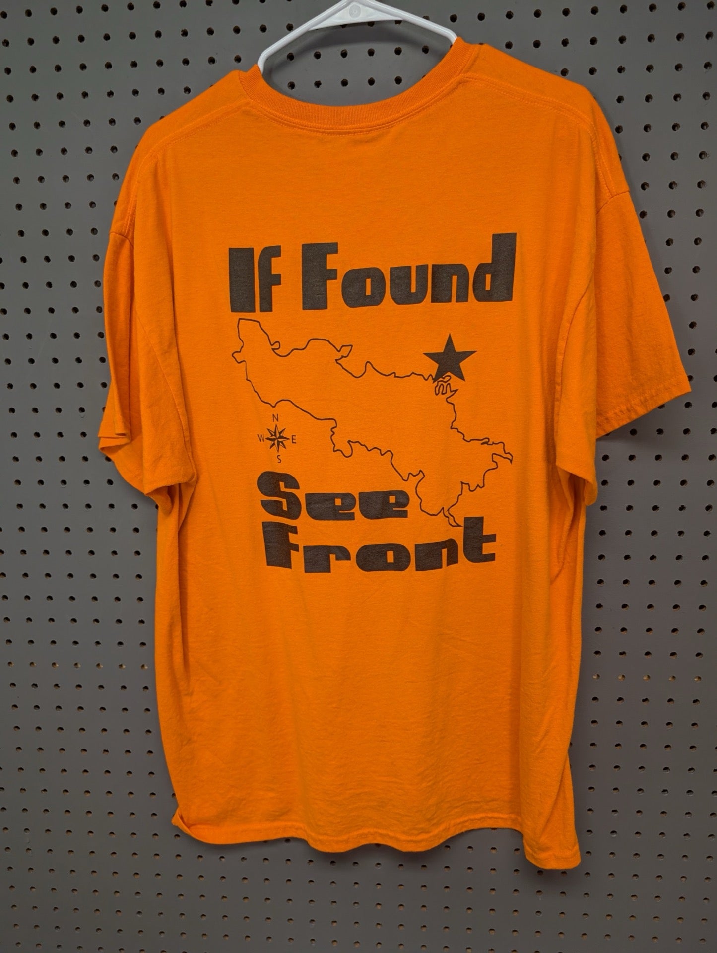 Back view of orange t-shirt with map and text