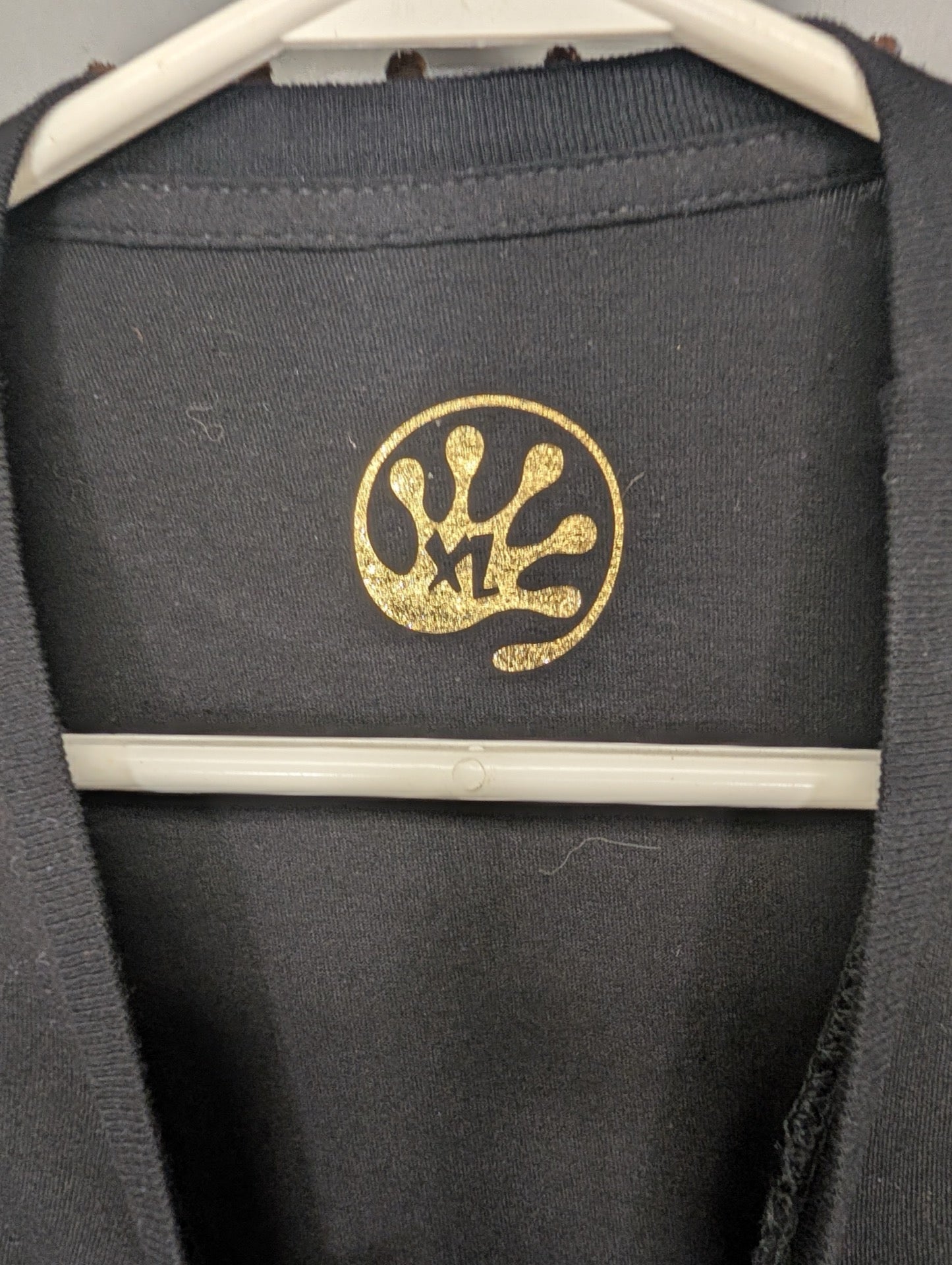 Gold hand logo XL tag on black shirt