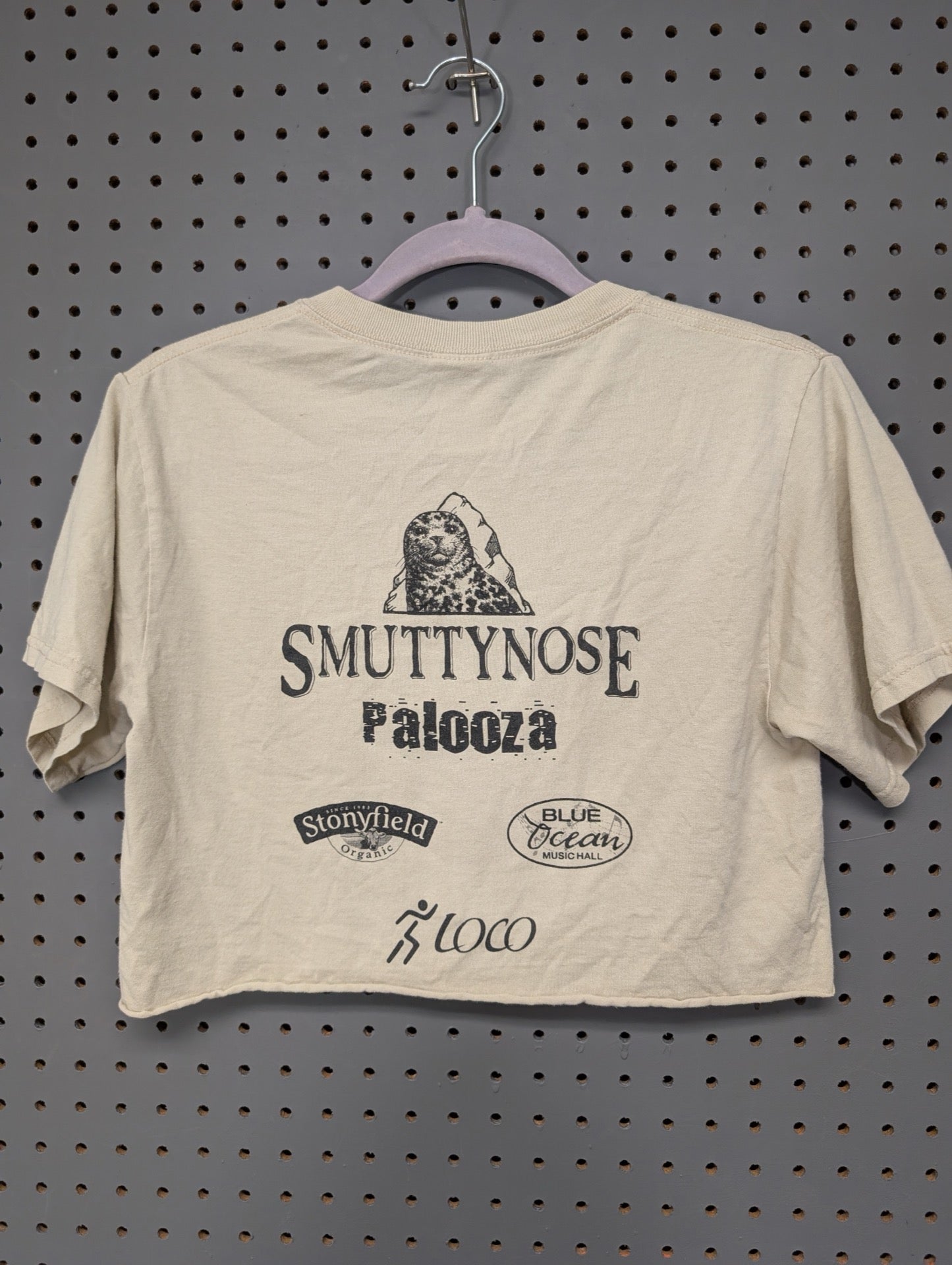 Back of beige Smuttynose crop top showing sponsor logos