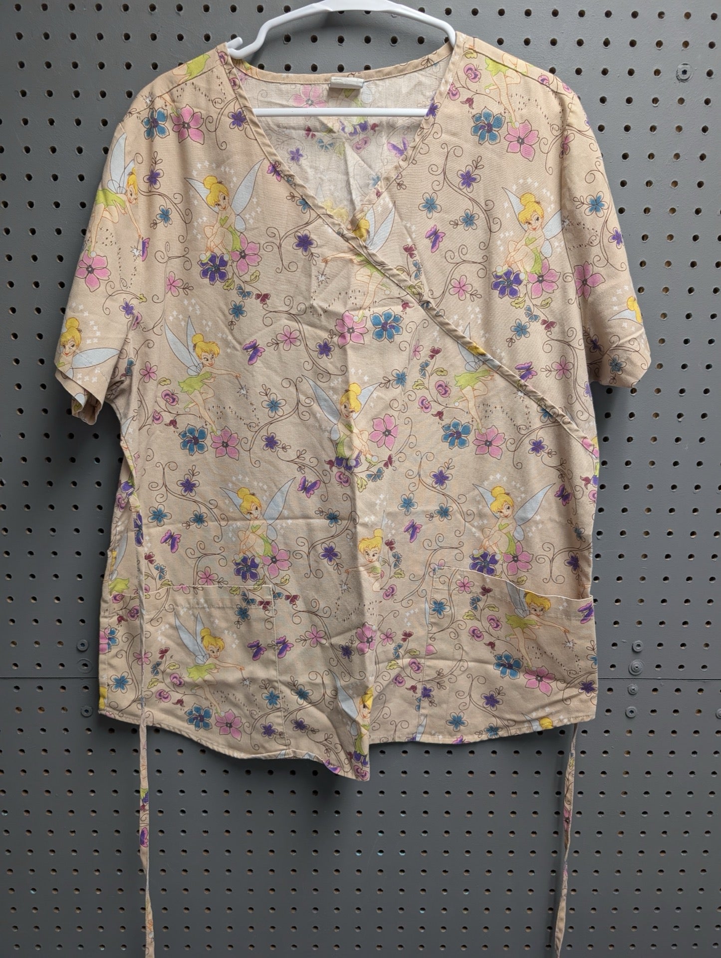 Front view of tan scrub top with Tinkerbell and floral print