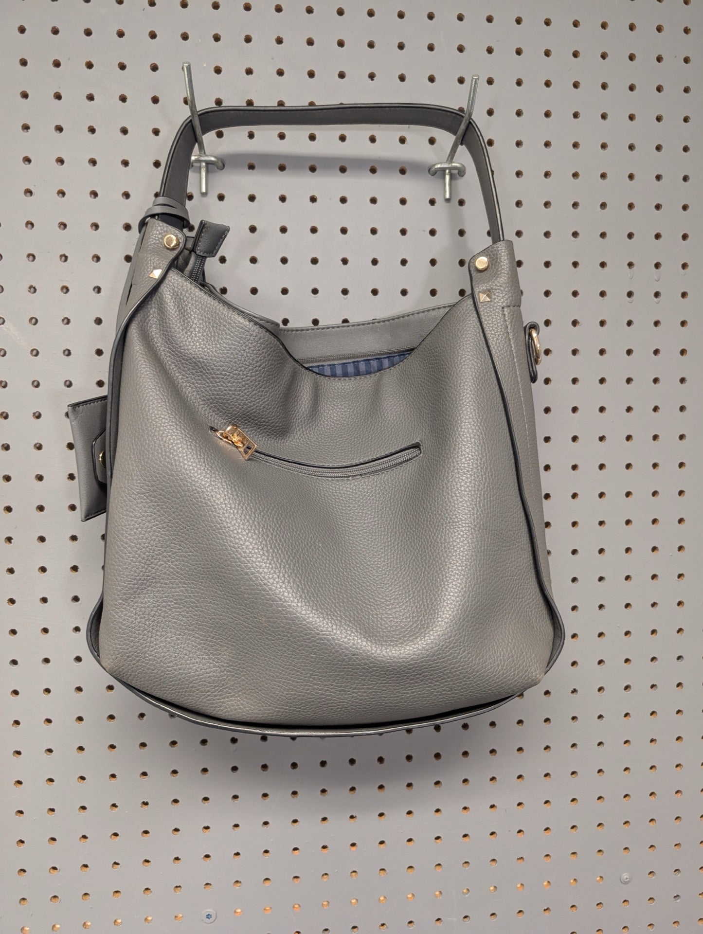 Back view of grey faux leather hobo bag on pegboard